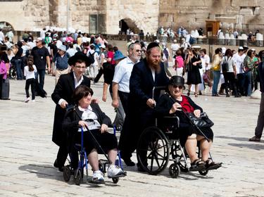 Men assisting women in wheelchairs at at the Western Wall, Jerusalem, Israel