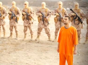 A man purported to be ISIS captive and Jordanian pilot Muath al-Kasaesbeh in front of armed men in a still image from an undated video filmed in an undisclosed location, made available on social media on February 3, 2015
