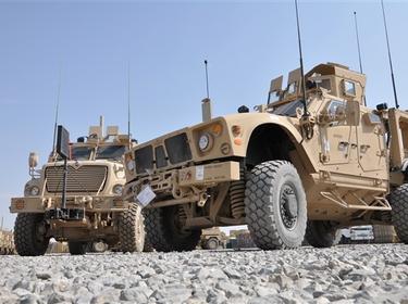 A mine-resistant, ambush-protected all-terrain vehicle, built specifically for the mountainous Afghan terrain, parked next to the larger MRAP, MaxxPro Dash