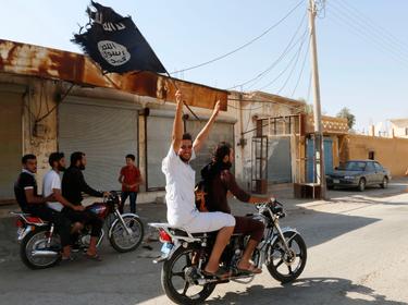 A resident of Tabqa city on a motorcycle waves an Islamist flag in celebration after Islamic State militants took over Tabqa air base, August 24, 2014