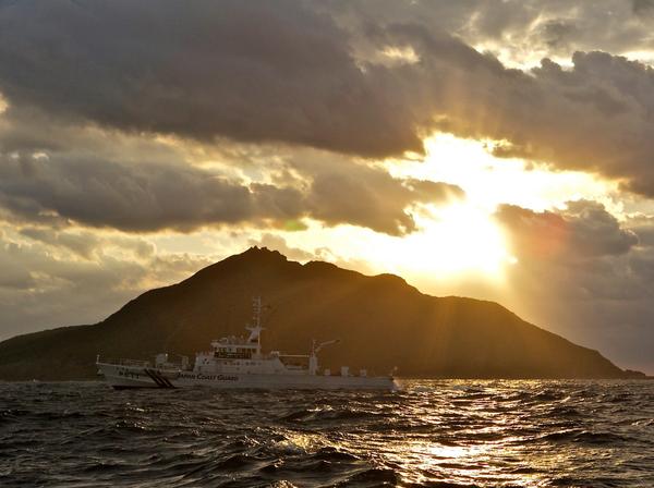 A Japanese Coast Guard patrol vessel passes by Uotsuri, the largest island in the Senkaku/Diaoyu chain