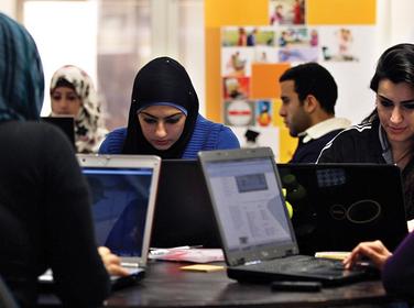 Young entrepreneurs work on their laptops at the Amman-based Oasis 500