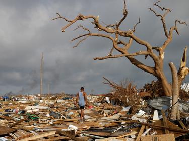 A man walks among debris at the Mudd neighborhood, devastated after Hurricane Dorian hit the Abaco Islands in Marsh Harbour, Bahamas, September 6, 2019, photo by Marco Bello/Reuters