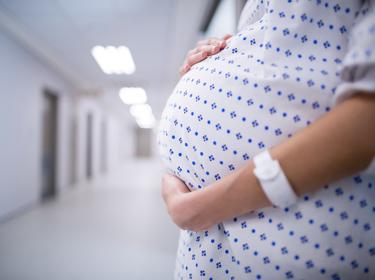 Pregnant woman standing in hospital corridor, photo by WavebreakMediaMicro/Adobe Stock