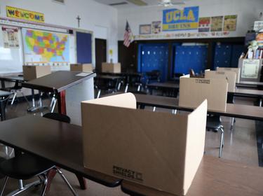 Social distancing dividers for students in a classroom at St. Benedict School in Montebello, near Los Angeles, California, July 14, 2020, photo  by Lucy Nicholson/Reuters