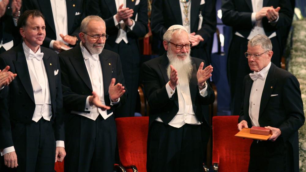 Thomas C. Schelling (right) is applauded by fellow Nobel laureates at the Stockholm Concert Hall, Sweden, December 10, 2005