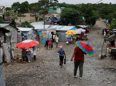 People walk down the street at a camp for displaced people while Hurricane Matthew approaches in Port-au-Prince, Haiti, October 3, 2016, photo by Carlos Garcia Rawlins/Reuters