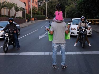 A Venezuelan refugee with his daughter on his shoulders asks for help at a traffic light in Medellin, Colombia, February 11, 2019, photo by David Himbert/Hans Lucas via Reuters Connect