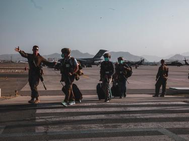 A U.S. Marine escorts Department of State personnel to be processed for evacuation at Hamid Karzai International Airport, Kabul, Afghanistan, August 15, 2021, photo by Sgt. Isaiah Campbell/U.S. Marines via Reuters