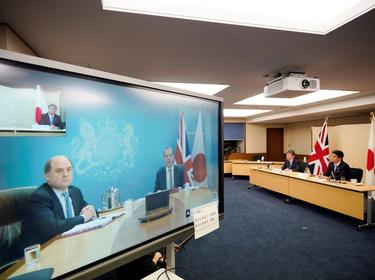 Japan's Defence Minister Nobuo Kishi and Foreign Minister Toshimitsu Motegi attend a video conference with Britain's Foreign Secretary Dominic Raab and Defence Minister Ben Wallace (on the screen) at the Foreign Ministry in Tokyo, Japan, February 3, 2021, hoto by Franck Robichon/Reuters