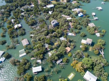 An aerial view of Central Texas homes under water at Graveyard Point neighborhood community in the flood plain of Lake Travis, photo by RoschetzkyIstockPhoto / Getty Images