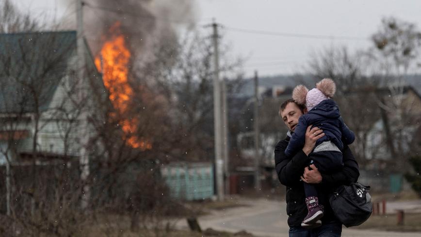Residents flee from the town of Irpin, Ukraine, after heavy shelling by Russia destroyed the only escape route used by locals, March 6, 2022, photo by Carlos Barria/Reuters