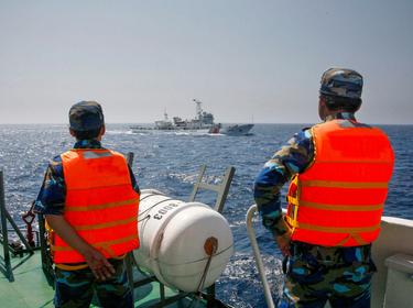 Officers of the Vietnamese Marine Guard monitor a Chinese coast guard vessel in the South China Sea, about 130 miles offshore of Vietnam, May 15, 2014, photo by Nguyen Minh/Reuters