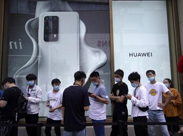 People stand in line in front of Huawei's new flagship store, as it officially opens in Shanghai, China, June 24, 2020, photo by Aly Song/Reuters