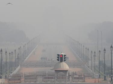People walk near India Gate on a smoggy afternoon in New Delhi, India, November 15, 2020, photo by Adnan Abidi/Reuters