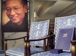 The Nobel certificate and medal is seen on the empty chair where Nobel Peace Prize winner jailed Chinese dissident Liu Xiaobo would have sat, near a portrait of Liu, at Oslo City Hall, December 10, 2010, photo by Heiko Junge/Scanpix Norway/Reuters