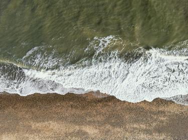 Top down aerial view of waves coming ashore on a shingle beach, photo by Nick Beer/AdobeStock