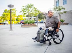 A young Hispanic American veteran college student using a wheelchair, going to class at college, photo by adamkaz/Getty Images