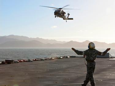 An Australian Army S70A-9 Black Hawk helicopter prepares to land on the flight deck of the Royal Australian Navy dock landing ship HMAS <em>Choules</em> in Townsville, Queensland, Australia, July 14, 2013,,photo by ABIS Cassie McBride/Australian Defense Force