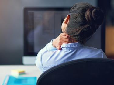 Businesswoman suffering from neck pain at the office