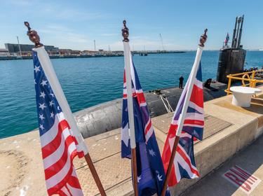 U.S., Australia and UK flags in front of the USS <em>Asheville</em>, a Los Angeles&ndash;class submarine, at HMAS Stirling, Western Australia, March 14, 2023, photo by AAPIMAGE via Reuters Connect