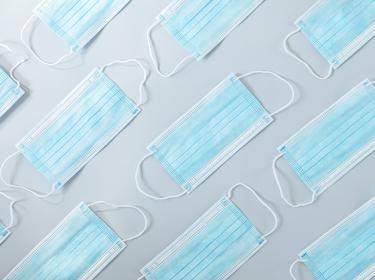 Repeating pattern of blue surgical masks, photo by Dmitriy Sidor/Getty Images