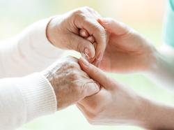 Closeup of the hands of a young woman holding the hands of an elderly lady, photo by hotographee.eu/Adobe Stock