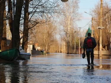 A figure walks through a flooded town