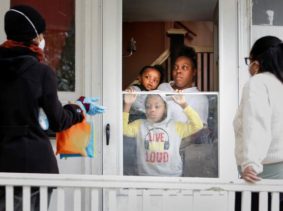 Sister Jenthia and Dr. Angela Branche speak to Natalie Hall as part of a door-to-door outreach program to the Black community to increase vaccine trial participation in Rochester, New York, October 17, 2020, photo by Lindsay DeDario/Reuters