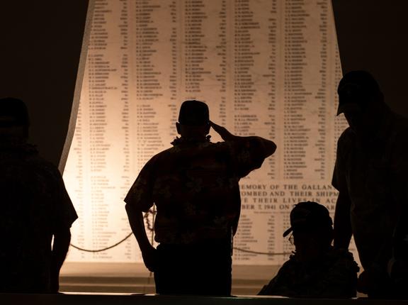 A neighbor and caretaker of a USS Arizona survivor salutes the wall of names at the USS Arizona Memorial at an interment ceremony on December 7, 2019, photo by PO1 Holly He/U.S. Marine Corps