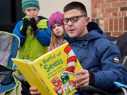 A student reads The Sneetches by Dr. Seuss during a peaceful demonstration at the Olentangy Schools Administration Building after a teacher who was reading Dr. Seuss on an NPR podcast was stopped by an administrator because questions about race came up, in Columbus, Ohio, January 16, 2023, photo by Barbara J. Perenic/USA Today via Reuters