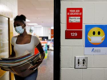 A Kindergarten teacher cleans and prepares her classroom, from where she will begin the new school year teaching virtually because of the COVID-19 pandemic, in Boston, Massachusetts, September 18, 2020, photo by Brian Snyder/Reuters