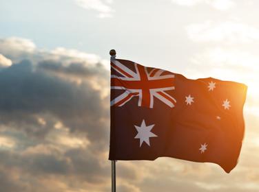 Waving Australia flag in the air at sunset, photo by baona/Getty Images