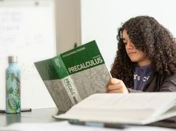 High school girl reading precalculus book