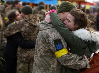 A woman hugs her boyfriend as they say good-bye prior to his deployment, at the train station in Lviv, Ukraine, March 9, 2022, photo by Kai Pfaffenbach/Reuters