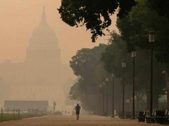 A person runs on the National Mall as the U.S. Capitol is shrouded in haze and smoke caused by wildfires in Canada, in Washington, D.C., June 8, 2023, photo by Amanda Andrade-Rhoades/Reuters
