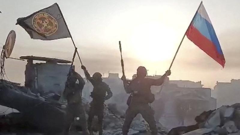 Wagner fighters wave flags of Russia and Wagner group on top of a building in an unidentified location in Ukraine in this still image obtained from a video released on May 20, 2023, photo by press service of Concord/Handout via Reuters